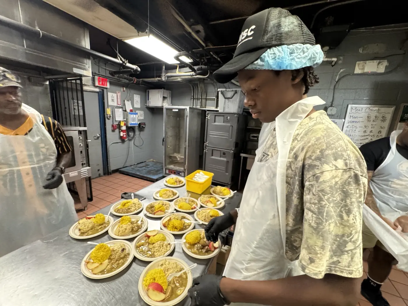 Moanalua Boys Basketball student-athlete preparing plated meals during a community food-service project