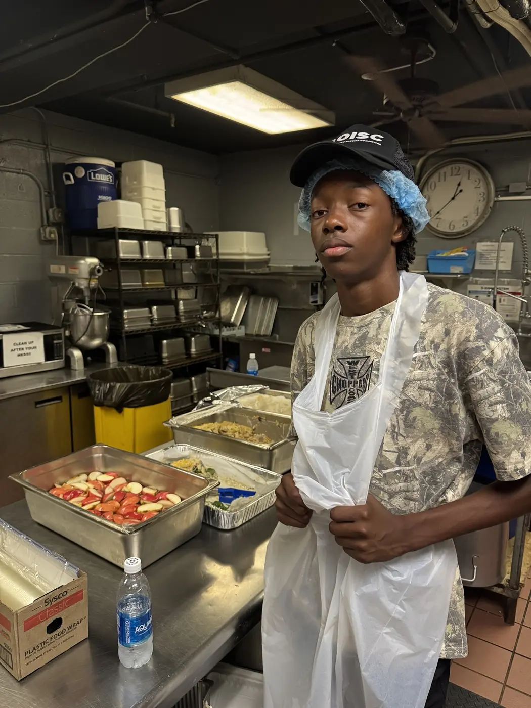 Moanalua Boys Basketball student-athlete volunteering in the kitchen during a community meal-service project