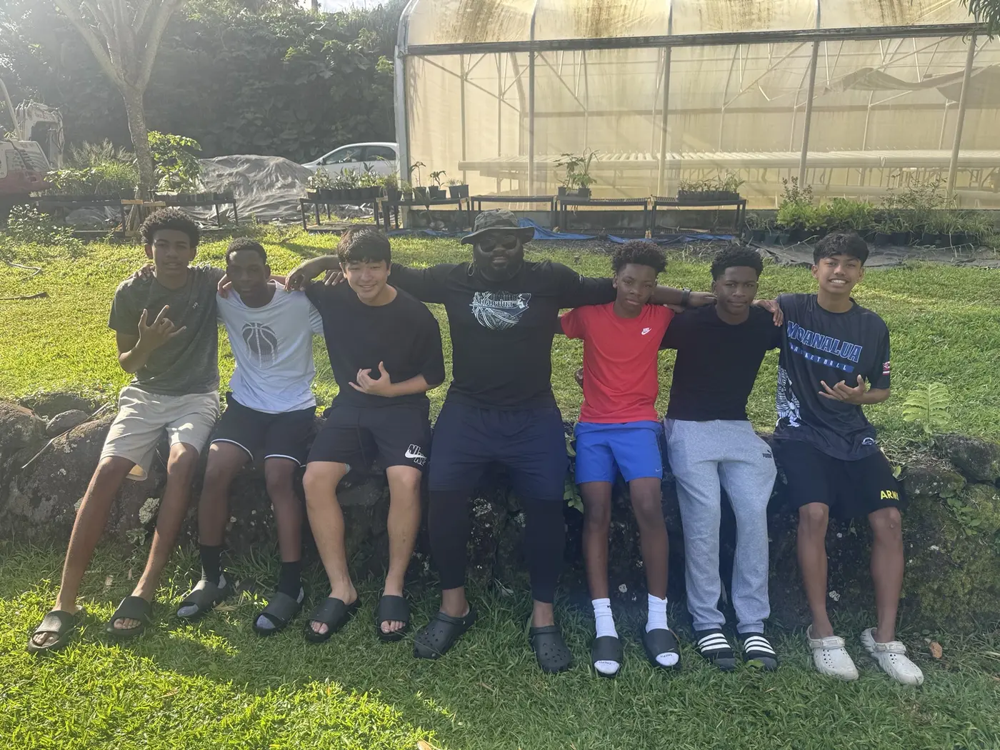 Moanalua Boys Basketball players and coach together during an outdoor community project