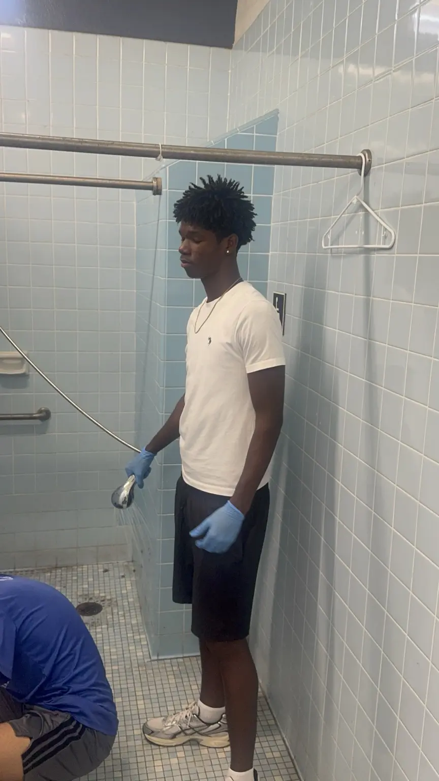 Student-athlete helping clean and care for a school facility
