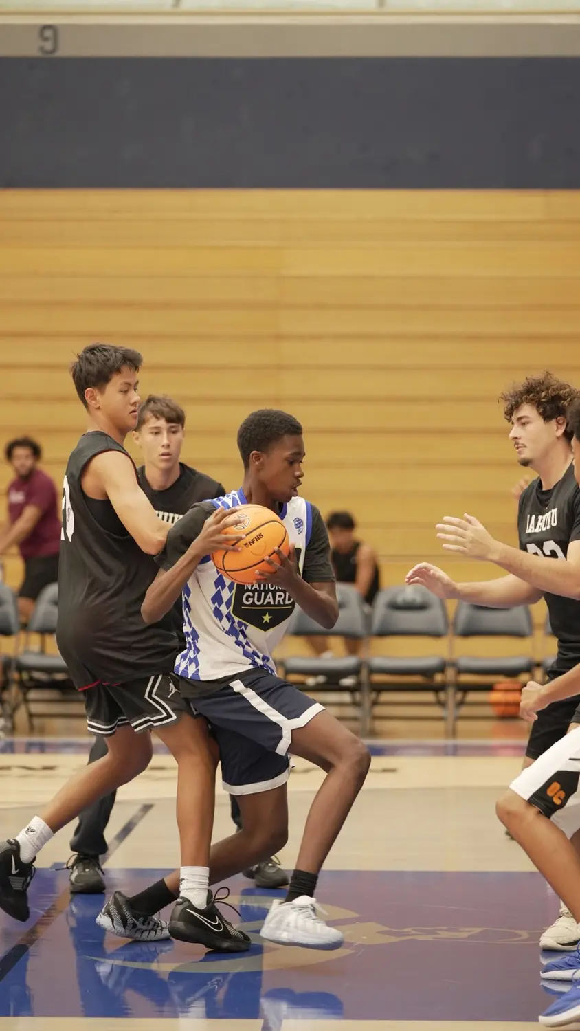 Varsity: Moanalua Fall League player protecting the basketball in traffic
