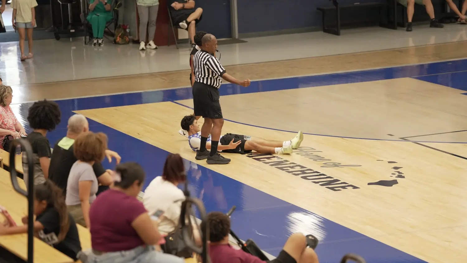 Varsity: Moanalua Fall League player on the floor after a hard-fought play